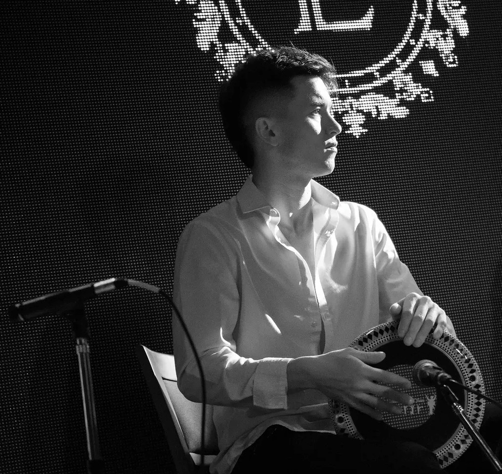 Lucas Cortese tocando frente al micrófono, en blanco y negro